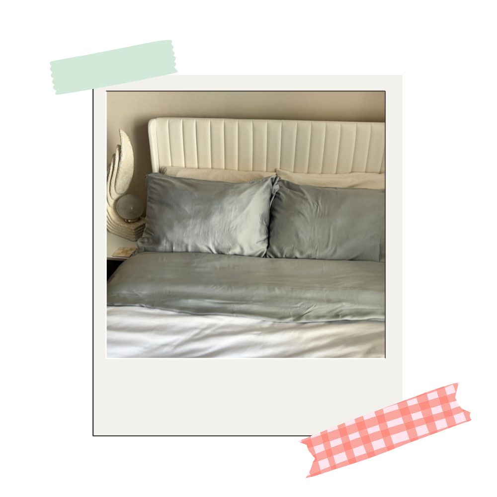 cozy earth pillowcase and top sheet in a light blue slash gray color on a bed