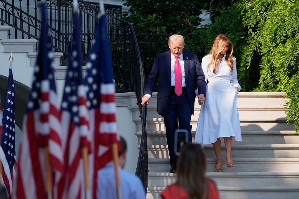 President Donald Trump and First Lady Melania Trump descend stairs after speaking to active-duty military service members and their families during a Fourth of July celebration on the South Lawn of the White House in Washington, DC on July 4, 2025. (Photo by Alex Brandon / POOL / AFP) (Photo by ALEX BRANDON/POOL/AFP via Getty Images)