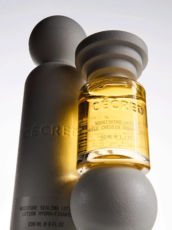 Cécred hair oil standing on top of the brand's other hair care products, shot from close up