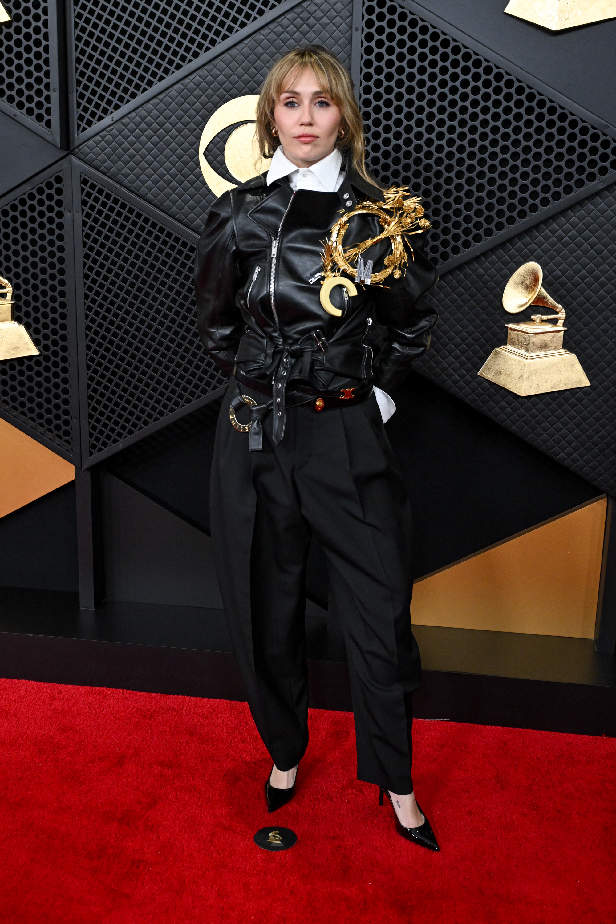 Miley Cyrus in a Celine look complete with a giant gold brooch at the 68th Grammy Awards. celebrity grammy style, Miley Cyrus outfits