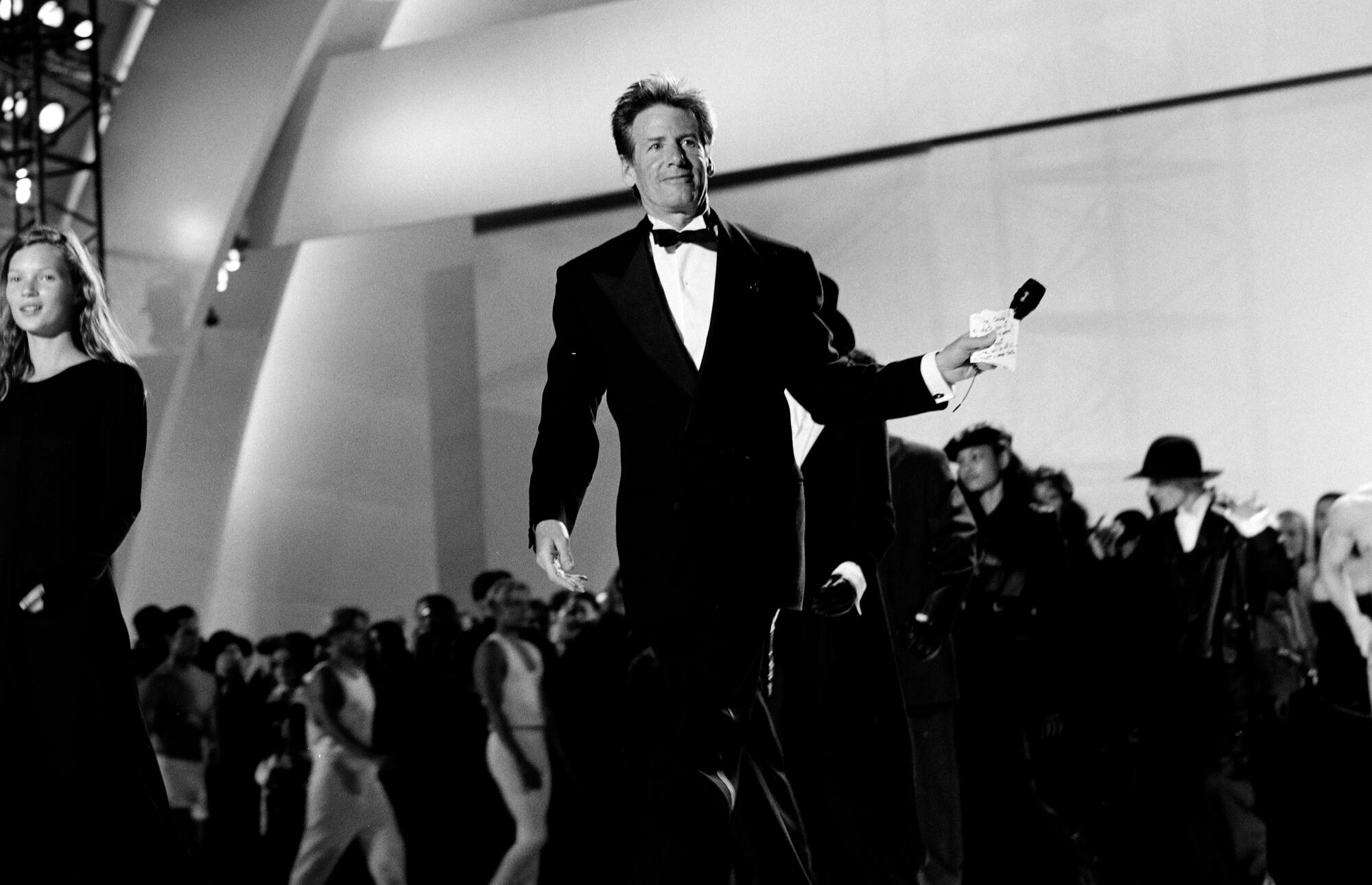 Kate Moss (L) and Calvin Klein (C) onstage during the AIDS Project LA mega-gala at the Hollywood Bowl on June 4, 1993.