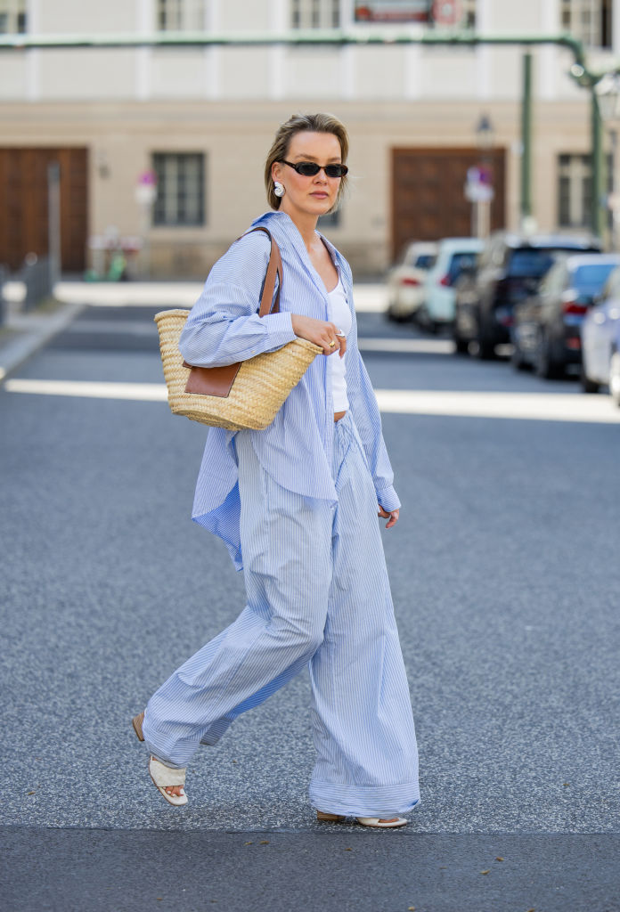 BERLIN, GERMANY - MAY 01: Tina Haase is seen wearing Arket blue striped button shirt and pyjama pants, Y Project white ribbed tanktop, beige Loewe Basket Bag, Celine Sunglasses on May 01, 2024 in Berlin, Germany. (Photo by Christian Vierig/Getty Images)